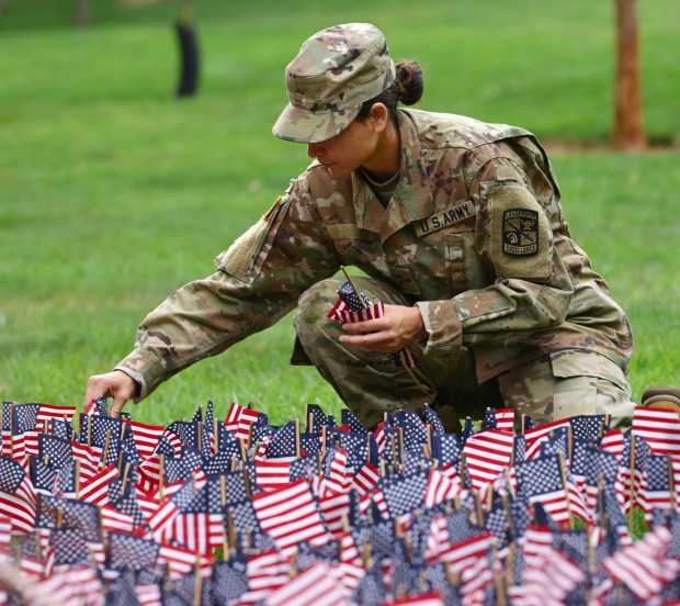 Kitira Bravo, places miniature American flags into the ground as Lehigh University and the Steel Battalion Army ROTC Program hold their annual 9/11 memorial event Friday, Sept. 11, 2026, in Bethlehem, to mark the 25th anniversary of the terror attacks. The ceremony included a flag raising, moment of silence and the planting of the 2,977 American flags to honor the lives lost. (Monica Cabrera/The Morning Call)