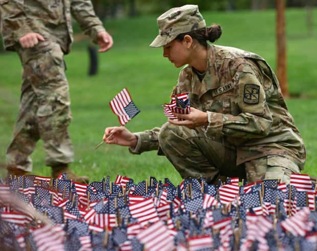 Kitira Bravo, places miniature American flags into the ground as Lehigh University and the Steel Battalion Army ROTC Program hold their annual 9/11 memorial event Friday, Sept. 11, 2026, in Bethlehem, to mark the 25th anniversary of the terror attacks. The ceremony included a flag raising, moment of silence and the planting of the 2,977 American flags to honor the lives lost. (Monica Cabrera/The Morning Call)