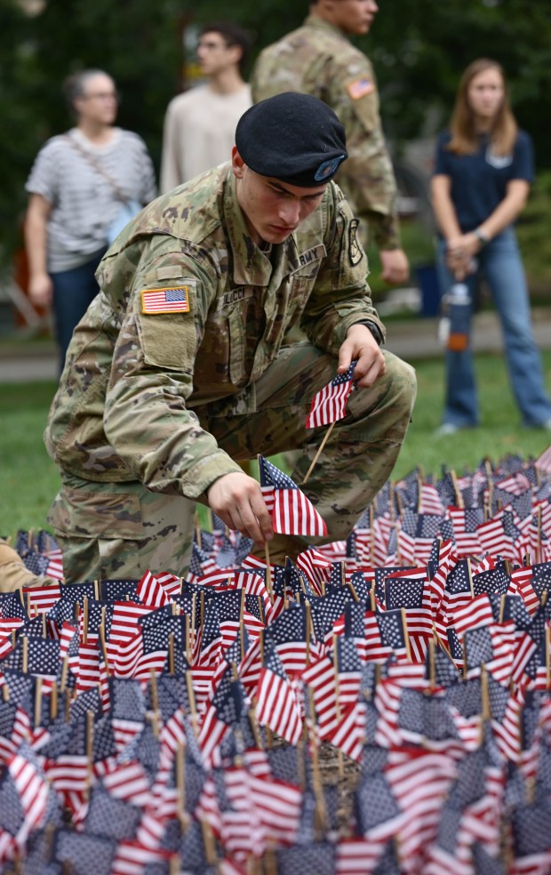 Cadet Joseph Colucci, places miniature American flags into the ground as Lehigh University and the Steel Battalion Army ROTC Program hold their annual 9/11 memorial event Friday, Sept. 11, 2026, in Bethlehem, to mark the 25th anniversary of the terror attacks. The ceremony included a flag raising, moment of silence and the planting of the 2,977 American flags to honor the lives lost. (Monica Cabrera/The Morning Call)
