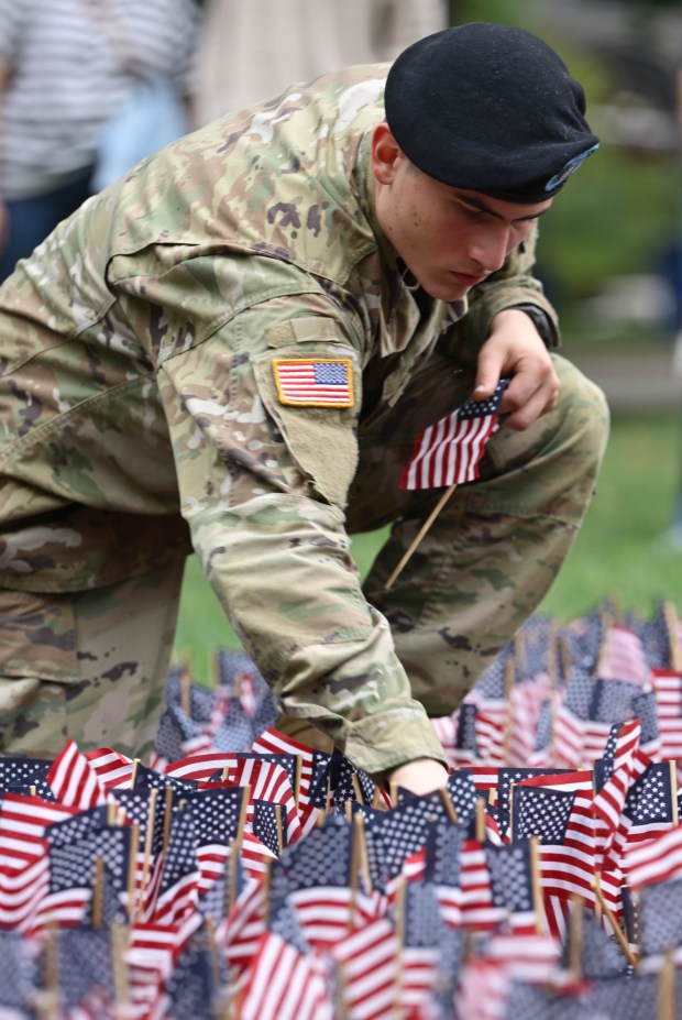 Cadet Joseph Colucci, places miniature American flags into the ground as Lehigh University and the Steel Battalion Army ROTC Program hold their annual 9/11 memorial event Friday, Sept. 11, 2026, in Bethlehem, to mark the 25th anniversary of the terror attacks. The ceremony included a flag raising, moment of silence and the planting of the 2,977 American flags to honor the lives lost. (Monica Cabrera/The Morning Call)