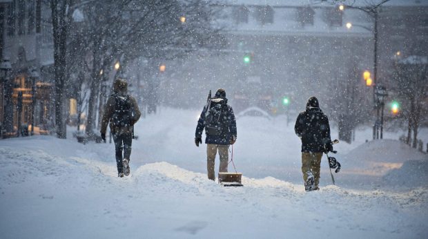 Three people make their way down Main Street in downtown Bethlehem with a sled and snowboard, looking to have fun, Monday, Feb. 1, 2021, as the Lehigh Valley received more than two feet of snow form a winter storm. (Rick Kintzel/The Morning Call)
