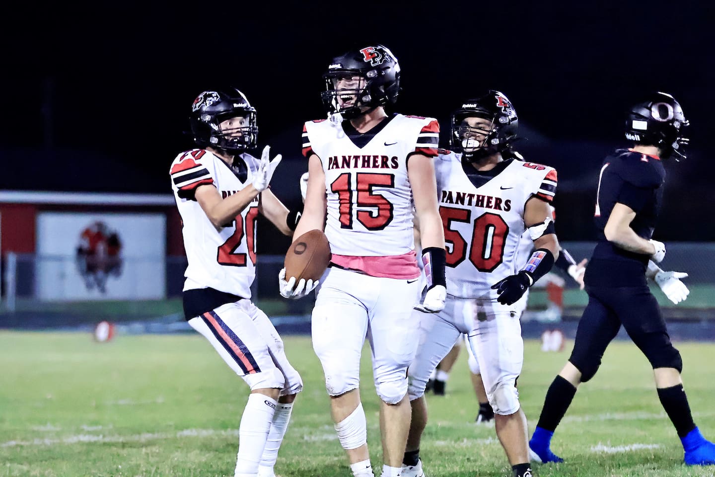 Erie-Prophetstown's Evan Steimle, center, celebrates his interception with teammates Lane Decker (20) and Jordae Crow (50) in a game against the hosting Orion Chargers last season.