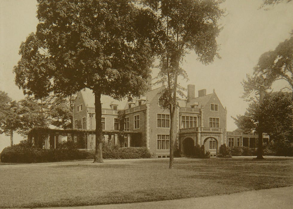 Historic mansion surrounded by trees and landscaped grounds, featuring a prominent entrance and large windows.