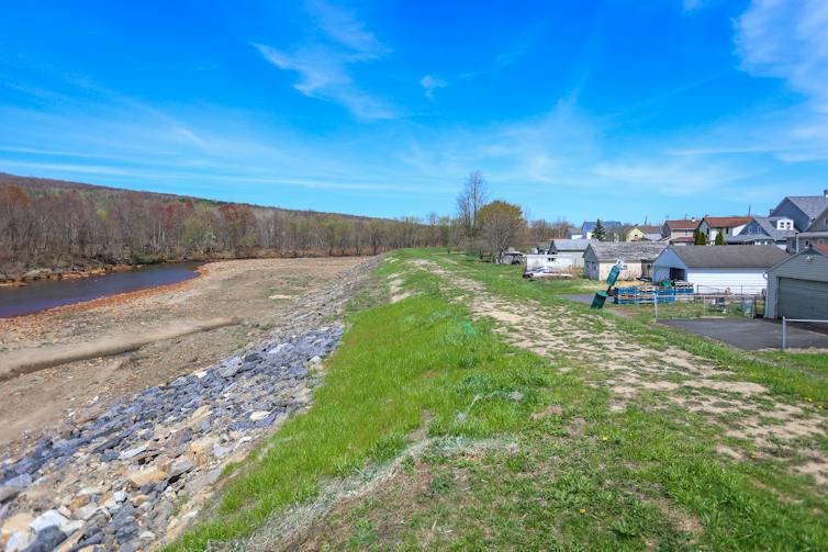 View of small embankment between body of water and houses
