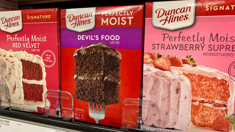 Duncan Hines cake mix boxes are displayed on a store shelf.