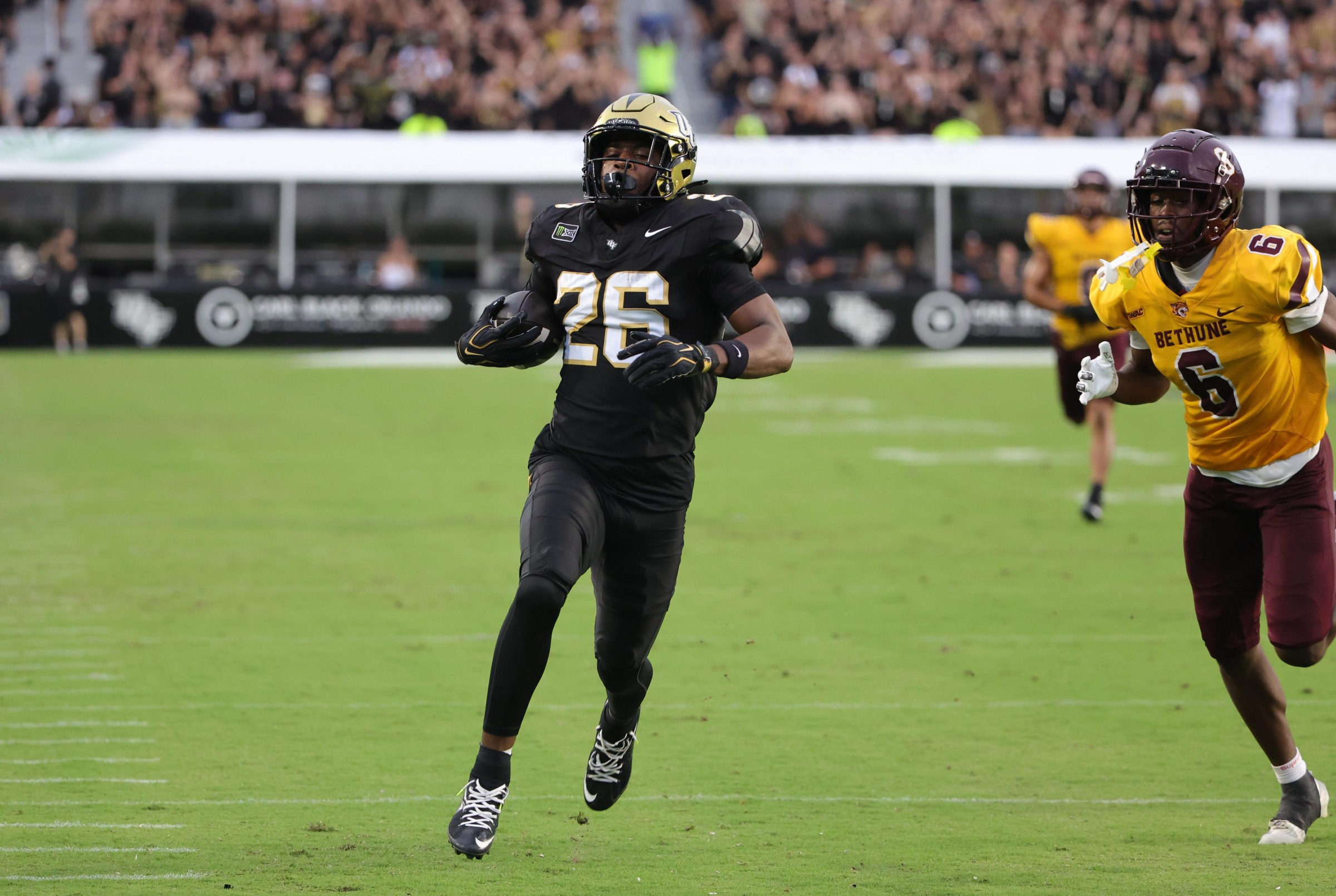 Sep 3, 2026; Orlando, Florida, USA; UCF running back Duke Watson (26) runs for a touchdown past Bethune-Cookman safety Naim Lassiter (6) during the first quarter at Acrisure Bounce House. Mandatory Credit: Mike Watters-Imagn Images