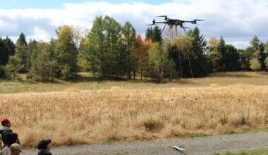 Drone with magnetometer sensor flying low over forested Pennsylvania hills searching for orphan wells, roughly 4 6