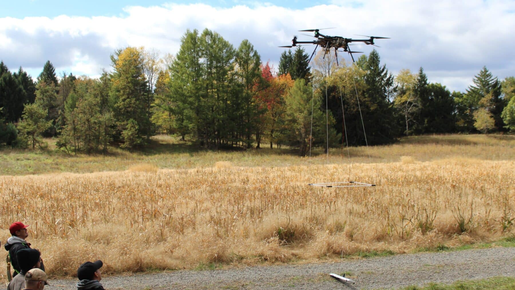 Drone with magnetometer sensor flying low over forested Pennsylvania hills searching for orphan wells, roughly 4 6