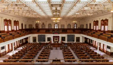 Spacious interior of the Texas State Capitol House Chamber with seating and elaborate ceiling. (stock photo via Pexels)