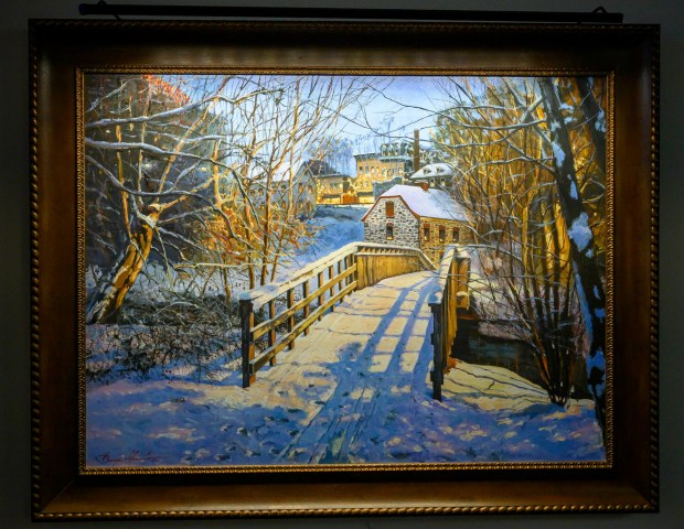 A painting of the 1754 Waterworks by Sergei Yaralov, one of four recently installed in the main dining room of Kirkland Village, is seen Friday, Oct. 2, 2026, in Bethlehem. Residents donated money to purchase the art, part of a collection of over 800 pieces. The 1754 Waterworks pumped spring water up to a water tower that stood where Central Church stands today, from which the water flowed by gravity to town buildings. The restored building, containing a waterwheel and a three-piston pump, is a National Historic Landmark and is known as the first municipal pumped water system in the United States. (April Gamiz/The Morning Call)