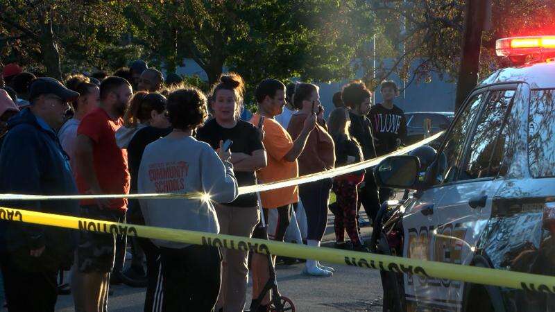 In this image from video provided by WJET, bystanders gather outside the scene of a shooting in Erie, Pa., on Friday evening, Oct. 9, 2026. (Matt Barnum/WJET via AP)