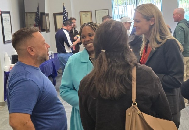 From left to right, Luzerne County Council Chairman Jimmy Sabatino, Council Vice Chairwoman Brittany Stephenson and Scranton Mayor Paige Cognetti, a Democratic congressional candidate, chat during a Northeast Pennsylvania Building & Construction Trades Council meeting on Friday, Oct. 16, 2026, in Wilkes-Barre. (Michael P. Buffer)