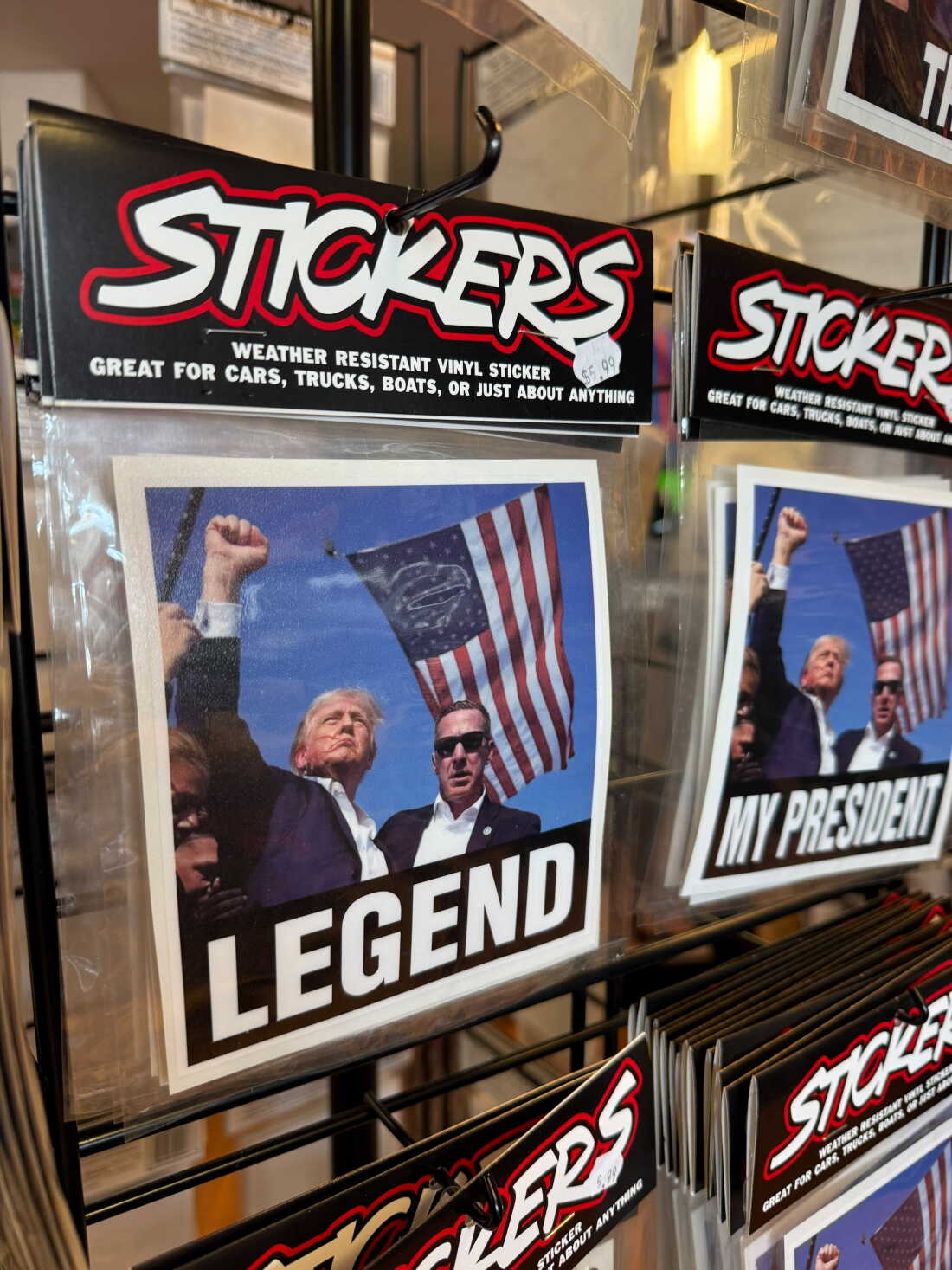 A sticker at a now-closed Trump store shows Trump pumping his fist after the assassination attempt in Butler, Pa.