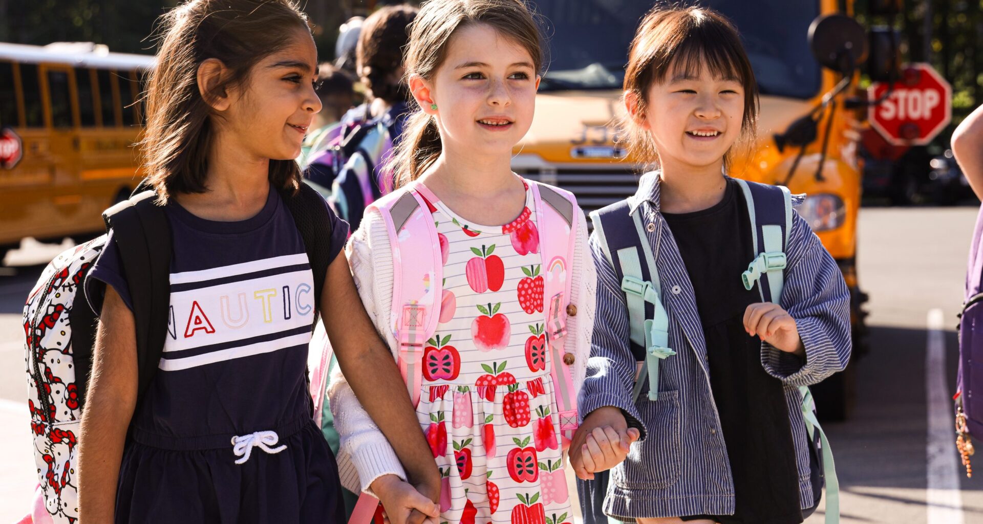 three students walking and holding hands