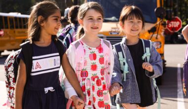three students walking and holding hands