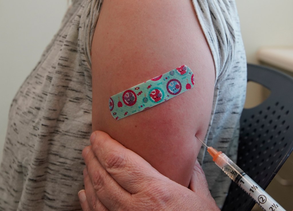 A nurse administers a measles, mumps, and rubella vaccine to a patient.