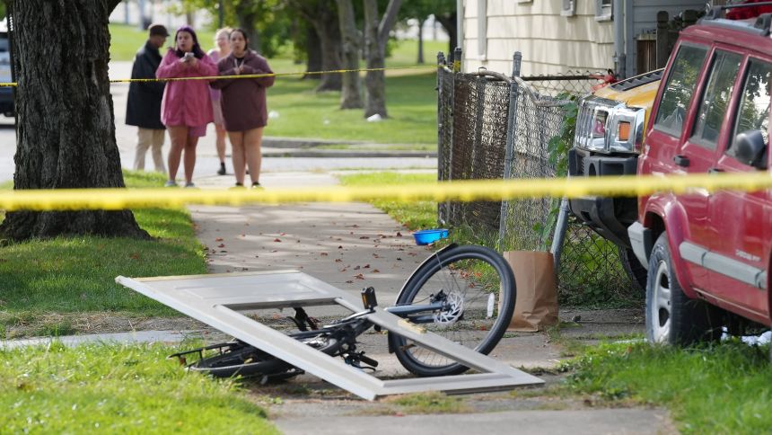 Bystanders gather near a house where nine people were confirmed dead in what was described as a mass shooting in Erie, Pennsylvania, on October 10.
