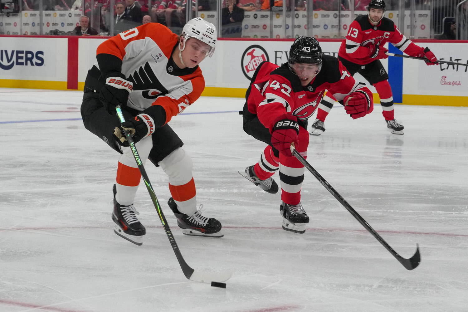 Oct 1, 2026; Newark, New Jersey, USA;  Philadelphia Flyers left wing Alex Bump (20) plays the puck as New Jersey Devils defenseman Luke Hughes (43) defends during the first period at Prudential Center.