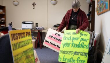 Sister Anne McCarthy with the Benedictine Sisters of Erie looks through her signs protesting President Trump's nationwide immigration crackdown. - WFMZ.com