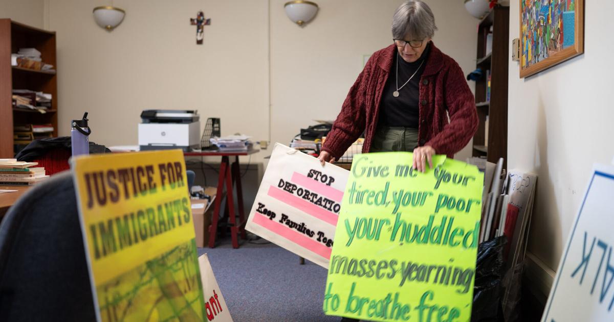 Sister Anne McCarthy with the Benedictine Sisters of Erie looks through her signs protesting President Trump's nationwide immigration crackdown. - WFMZ.com