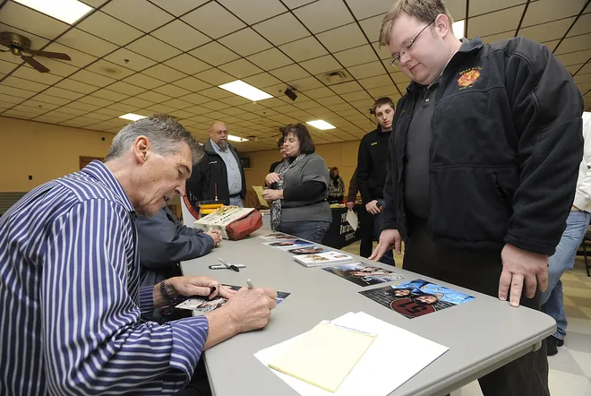 Randolph Mantooth, left, who starred as Johnny Gage in the 1970's TV show "Emergency" signs an autograph for Jerry Hickin, of Millcreek Paramedic Services, during a meet and greet with members of the Belle Valley Fire Department and Millcreek Paramedic Services at the Belle Valley Fire Department, in Millcreek Township, on Nov. 8, 2013. Mantooth will be the keynote speaker, Saturday night during the celebrations for the Belle Valley Fire Department's 75th anniversary. JACK HANRAHAN/