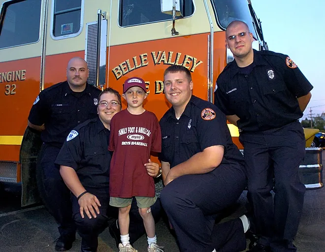 Belle Valley Fire Department members, left to right, Shannon Goho, Lieutenant,Chris Piganelli, firefighter, Patrick McKellop, firefighter and Allen Lombardozzi, EMS Coordinator, with Christian Olson, 6, who was choking on candy during the zoo parade, when the Belle Valley crew rushed to his aide on June 7, 2006.