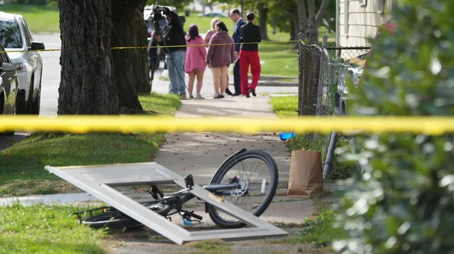 Bystanders and journalists gather near where multiple people were killed in a reported shooting in and around a home at 722 Perry St. in Erie, Pa., Oct. 9, 2026. Erie Bureau of Police investigators were on the scene Oct. 10. Vigil draws 175 friends, family to site of mass shooting in Erie