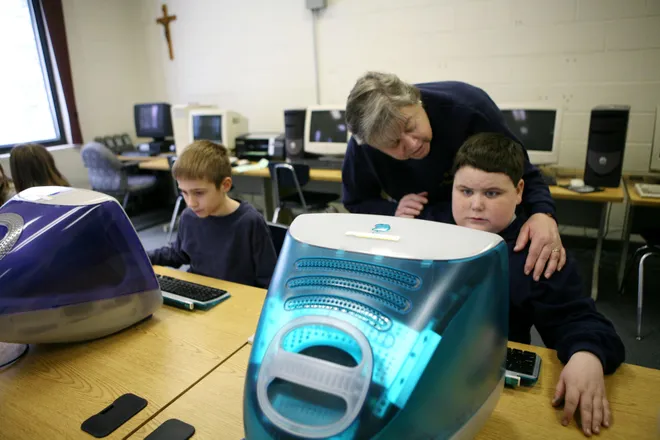 Austin Klenz, 9, a third-grader at St. Gregory's Catholic School, gets help with his spreadsheet from teacher Joan Bereb in January 2007.
