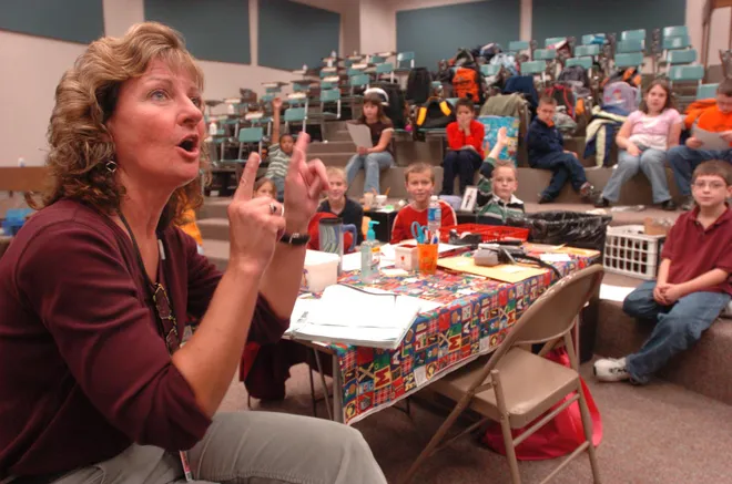 Klein School music teacher Sheryl May teaches her fourth-grade students in the auditorium at Rolling Ridge Elementary School in September 2006, when Klein School was closed because of flooding.