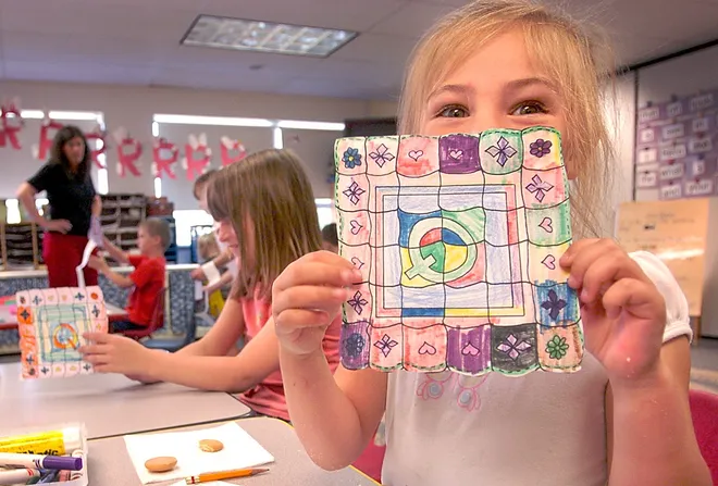 Malyna Zboyvski, 6, a kindergarten student at Edinboro Elementary School, shows off her artwork in May 2007. Next to her is Lena Mitcho. Teacher Marie Troyer is at far left.