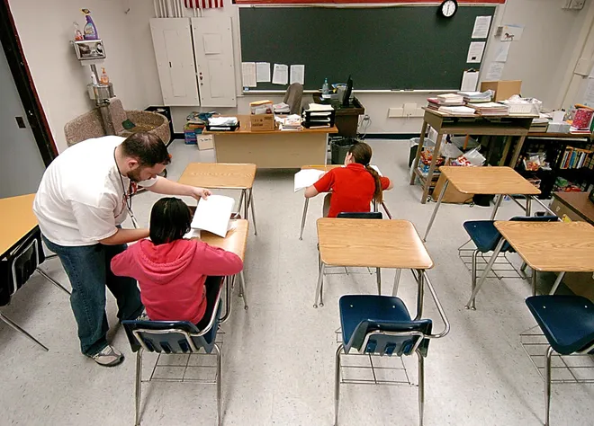 Wayne School teacher and PSSA test proctor T.J. Wieczorek, left, helps two students start a portion of their test March 16, 2007. Wayne School in Erie PA final decade in photos