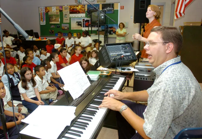 Music teacher Dana Gilmore conducts a group of about 70 fourth- and fifth-graders during a choir class at McKinley Elementary School on Oct. 3, 2007. The class was trying to raise $18,000 for 40 students to travel to Philadelphia to be a part of an 800-voice choir to be featured in the Macy's Day Parade on Thanksgiving Day. 2025: McKinley Elementary students arrive for first day of school in Erie