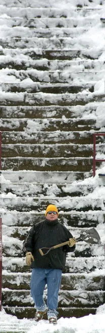 Tom Torok, a teacher of special needs students from Central Tech High School, finishes clearing snow from the steps in the southeast corner of Veterans Stadium in December 2007 in preparation for a state Class AAA playoff semifinal game between Strong Vincent of Erie and Thomas Jefferson.