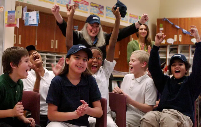 Harding Elementary School sixth-graders celebrate a correct answer by Lydia Jobczynski, third from left, while playing Classroom Jeopardy Dec. 10, 2007. The students were treated with a visit from Jeopardy Clue Crew member Jimmy McGuire and the school was given the game to keep. The students, from left, are Michael Geisecke, Victoria Coleman, Jobczynski, Erika Thomas, Ryan Hatkevich, all 11 years old, and Zachary Scott, 12. In back are teacher Kathleen Green, with hat, and student teacher Jenna Perpich.