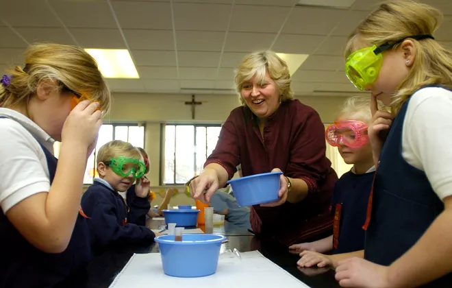 Mary Swonder, St. Boniface Elementary School science teacher, center, points to a milliliter tube filled with cranberry juice that students Katie Kuzma, 7, left going clockwise, Joey Wilcynski, 7, Julie Wilczynski, 7, Erin Cox, 7, tested to see if the juice was an acid or base on Oct. 25, 2007.