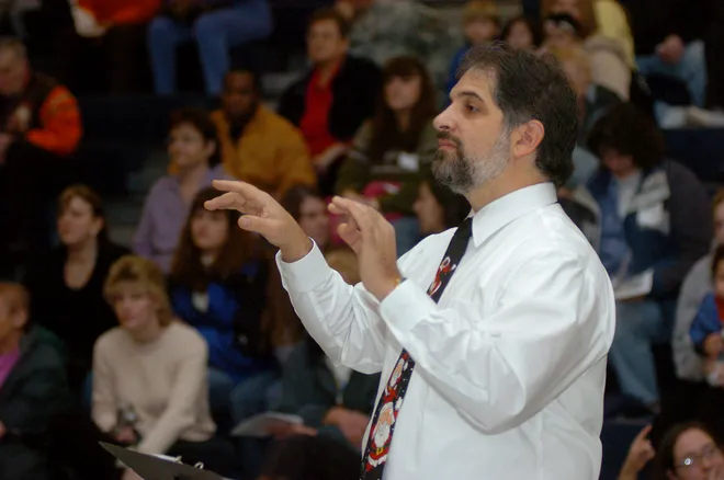 Tony Roussos, music teacher at Joanna Connell Elementary School, conducts grades kindergarten through six during their Christmas concert at the school on Dec. 20, 2007.
