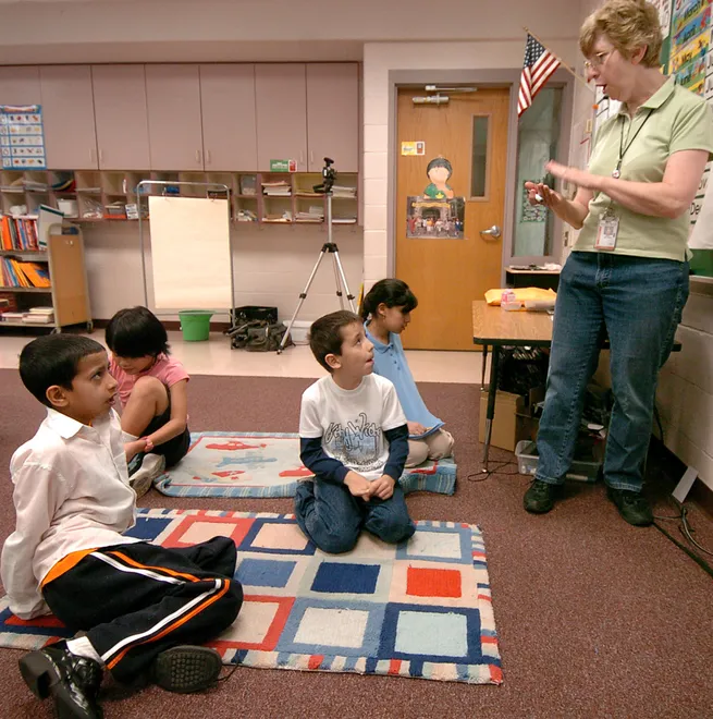 Naresh Timsina, 10, left, practices saying the months of the year with English teacher Ann Metzger at McKinley Elementary School on May 2, 2008. Metzger works with children of immigrant families as they transition to school in Erie. Timsina comes from Bhutan. Orkhan Badirov, 7, center, was born in Russia.