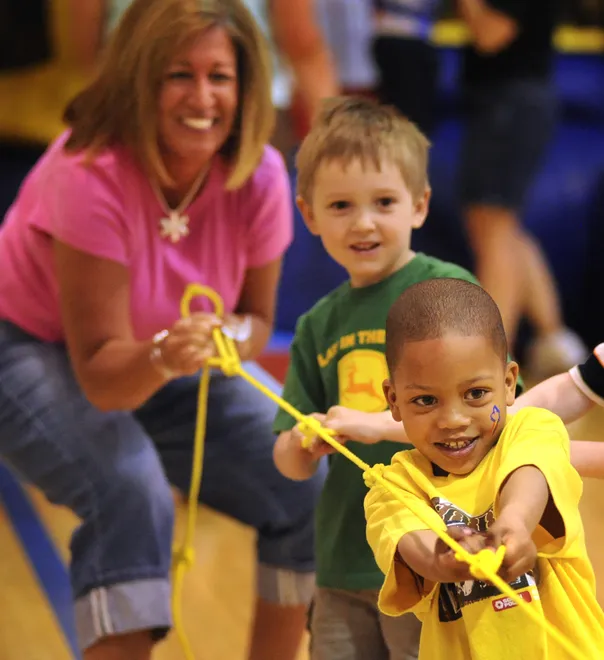 Dr. Gertrude A. Barber National Institute students Zachary Walter, 6, (foreground) and Logan Rinderle, 4, participate in a game of tug of war with the help of teacher Stephanie Lorei during field day events in the center's gymnasium June 3, 2008.