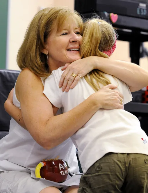 Glenwood Elementary School first-grade teacher Nancy Waros hugs student Lindsay Dougherty, 7, on the last day of instruction at the school on June 6, 2008. Waros was retiring after teaching for 31 years.
