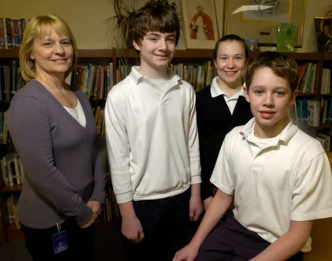 Cathedral Center School seventh- and eighth-grade English teacher Jacquelyn Shaffer with her students, from left, Nick Filippi, 12, Andrea Boris, 13, and Luke Merski, 12, in April 2008. The students won awards in an essay contest offered by the Erie Peace and Justice Center. Merski won first, Filippi won second and Boris won third place in the contest.