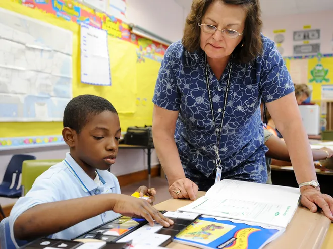 Wilson DeLee, 9, works on a math problem with help from teacher Maria Alvarado-Gomez at Jefferson Elementary School in Erie on June 23, 2008, during the first day of summer school in the Erie School District.