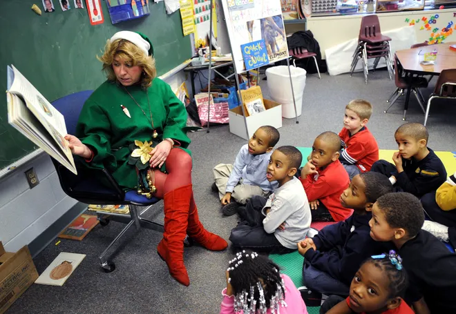 McKinley School kindergartners listen to their teacher, Susan McGill, as she reads them the book "Kate and the Beanstalk" during Literacy Day on Dec. 19, 2008. Students in kindergarten, first and second grades received a book as a gift from Santa Claus. The children's parents were also invited to the school to participate in workshops about how to assist their child in literacy. The school provided a luncheon for parents with pizza donated by Hungry Howie's and antipastos by Nunzi's.