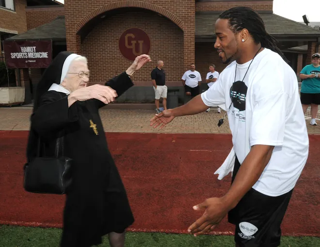 Sister James Francis hugs NFL star Bob Sanders at his Skills and Drills Football Camp at Gannon University on July 27, 2008. Sister Francis was Sanders' freshman English teacher when he attended Cathedral Preparatory School. She had a friend drive her to the camp so she could see Sanders.