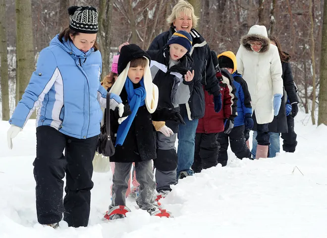 Belle Valley Elementary School teacher Jen Hoover, left, helps student John Rossi, 7, snowshoe at Asbury Woods Nature Center in Millcreek Township on Jan. 29, 2009.