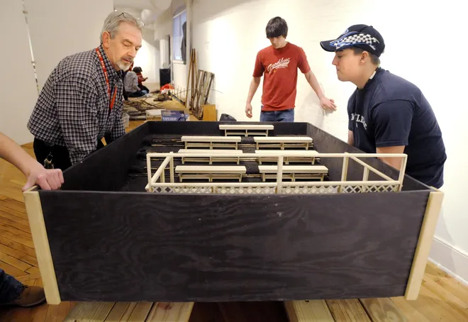From left, John Kieffer, a technology education teacher at General McLane High School, and Mike Littlefield and Dan Williams, both ninth-graders at McLane, place part of the model amphitheater for the Kids as Curator exhibit at the Erie Art Museum Annex on Jan. 29, 2009.