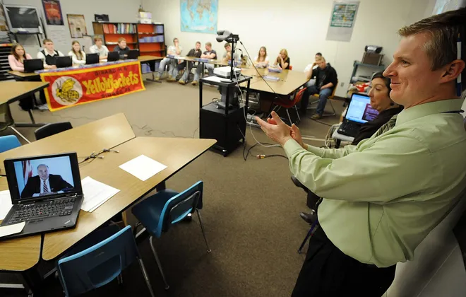Girard High School American government teacher Matt Mikovich , right, applauds a point made by Pennsylvania Governor. Ed Rendell, shown on laptop speaking from Harrisburg, left, during a video conference with 10 high schools across the state including Girard High School in Girard on Feb. 25, 2009. Rendell spoke about education and state budget concerns, then fielded questions from the schools.