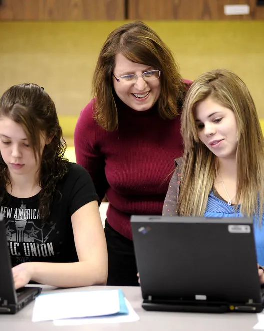 Family and consumer sciences teacher Jeannie Lamb looks over resumes with Jamie Wilkins, 17, left, and Sarah Sheehan, 18, on Feb. 4, 2009, at North East High School. Lamb's students used cookstoves less and the laptop computers more as they focused less on food and cooking and more on preparing and maintaining personal budgets and resumes