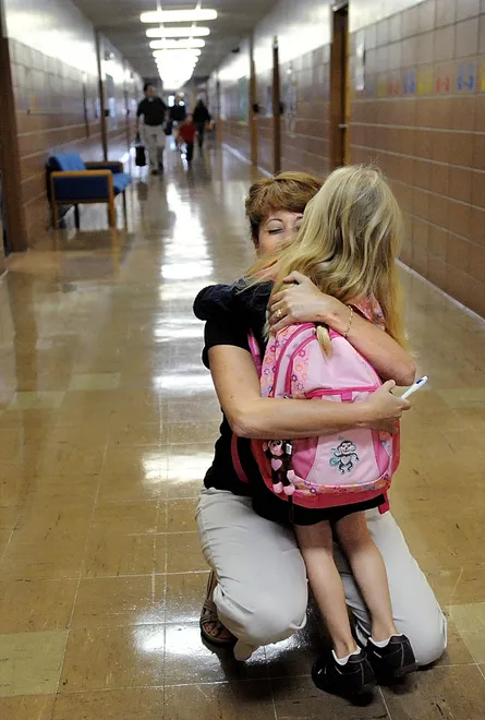 Grover Cleveland Elementary teacher Andrea Gloystein greets incoming kindergarten student Emma Revak in one of the main hallways of the school Aug. 31, 2009.