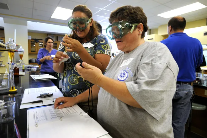 Racquel Thurau, a teacher at Union City High School, left, and Sharon Yu, a teacher at Villa Maria High School, right, test viscosity levels during Gannon University's biodiesel fuel workshop for local high school teachers at the Zurn Science Center on June 12, 2009.