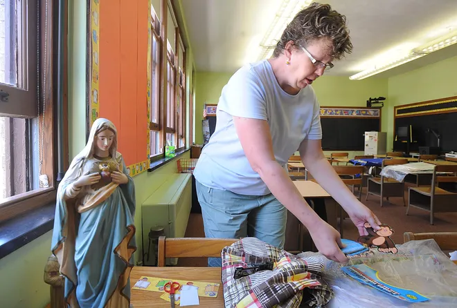 Mary Anne DeCoursey, a second-grade teacher at Holy Family School, in Erie, decorates her classroom in August 2009 in preparation for the first day of school.